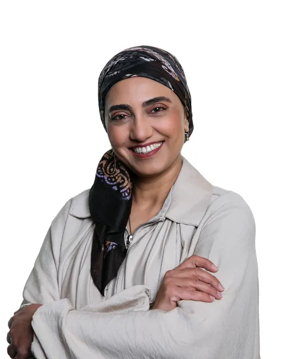 Rumana Mahomed smiling with her arms crossed